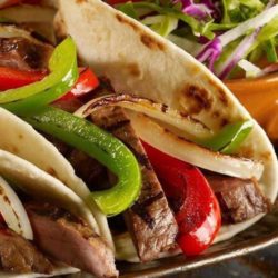 Recipe for Steak Fajitas - Classic Tex Mex, fajitas are typically made with grilled flank steak with onions and bell peppers, and served sizzling hot with fresh tortillas, guacamole, sour cream, and salsa.