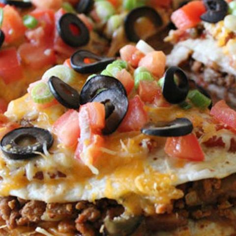 A tasty and easy Mexican-style pizza – delicious corn tortillas topped with beans, beef and all the delicious taco toppings you can imagine!