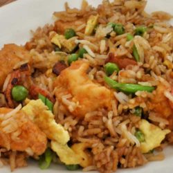 Spicy and sweet orange chicken is served with vegetable fried rice. You may never order take-out again!
