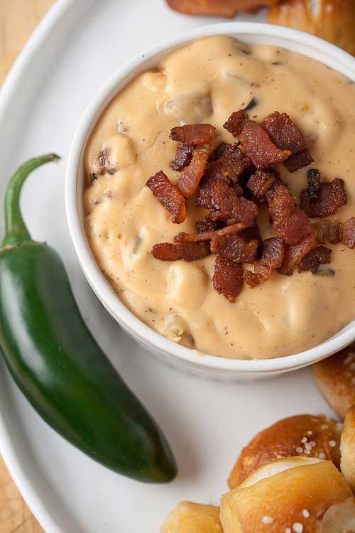 Recipe for Jalapeno Bacon Queso Dip - There are hot dips…and then there's this cheddar-jalapeño dip with chopped bacon and a kick of garlic. It's a keeper!
