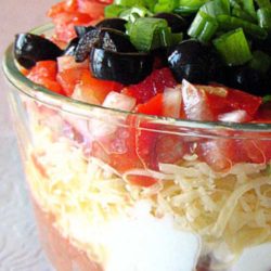 Recipe for Tex-Mex Seven Layer Dip - Without a doubt, my favorite party food is seven layer dip. With one deft swoop of a wide-brimmed tortilla chip, you can shovel seven unique tastes and textures into your open mouth at once.