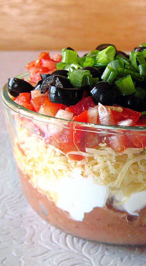 Recipe for Tex-Mex Seven Layer Dip - Without a doubt, my favorite party food is seven layer dip. With one deft swoop of a wide-brimmed tortilla chip, you can shovel seven unique tastes and textures into your open mouth at once.
