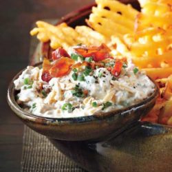 Recipe for Loaded Baked Potato Dip - Use extra-crispy waffle fries as dippers in this delicious concoction and don’t forget the crumbled bacon and hot sauce!