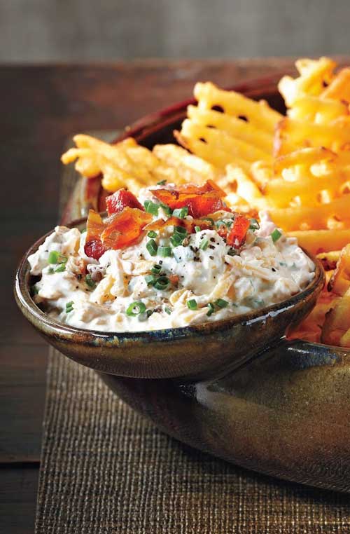 Recipe for Loaded Baked Potato Dip - Use extra-crispy waffle fries as dippers in this delicious concoction and don’t forget the crumbled bacon and hot sauce!