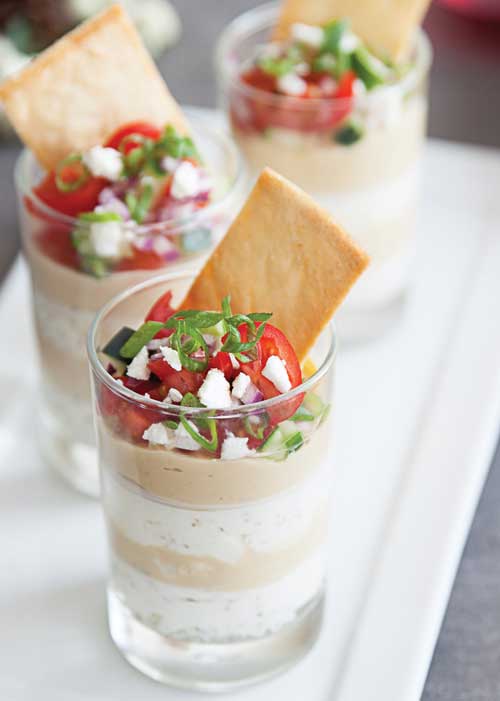 Start your game day crowd off with a 7-layer hummus dip, the perfect blend of veggies and cheese!