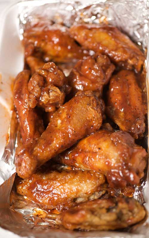 Recipe for Lightened-up Sweet and Spicy Chicken Wings - Wings are easy to make at home, and baking them in the oven cuts down on the fat and grease. Impress your friends with our sweet and spicy homemade version.