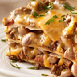 Recipe for Our Favorite Mexican-Style Lasagna - Create a little fusion with ooey-gooey cheese, beans and taco beef layered up and baked like lasagna.
