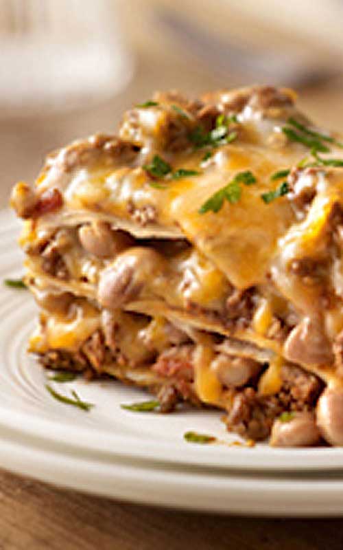 Recipe for Our Favorite Mexican-Style Lasagna - Create a little fusion with ooey-gooey cheese, beans and taco beef layered up and baked like lasagna.