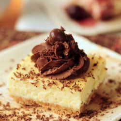 Recipe for Zabaglione Cheesecake - A rich, smooth, and delightful cheesecake combination set on an almond crumb base and glazed with a decadent trufle fudge frosting.