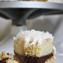 Recipe for Coconut Layer Cake with Chocolate Ganache Filling - If you like chocolate and coconut together, you’re going love this cake topped with Swiss meringue buttercream and coconut flakes!