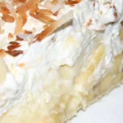 Recipe for Banana Cream Pie - This fluffy banana cream pie recipe is piled high with fresh ripe bananas and creamy vanilla filling, then topped with pillowy whipped cream and toasted coconut.